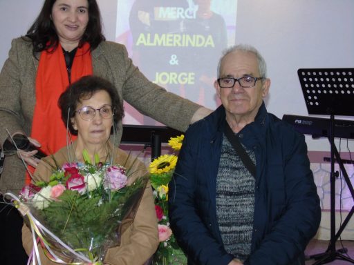 Une femme et un homme, tous deux souriants, posent avec un bouquet de fleurs.